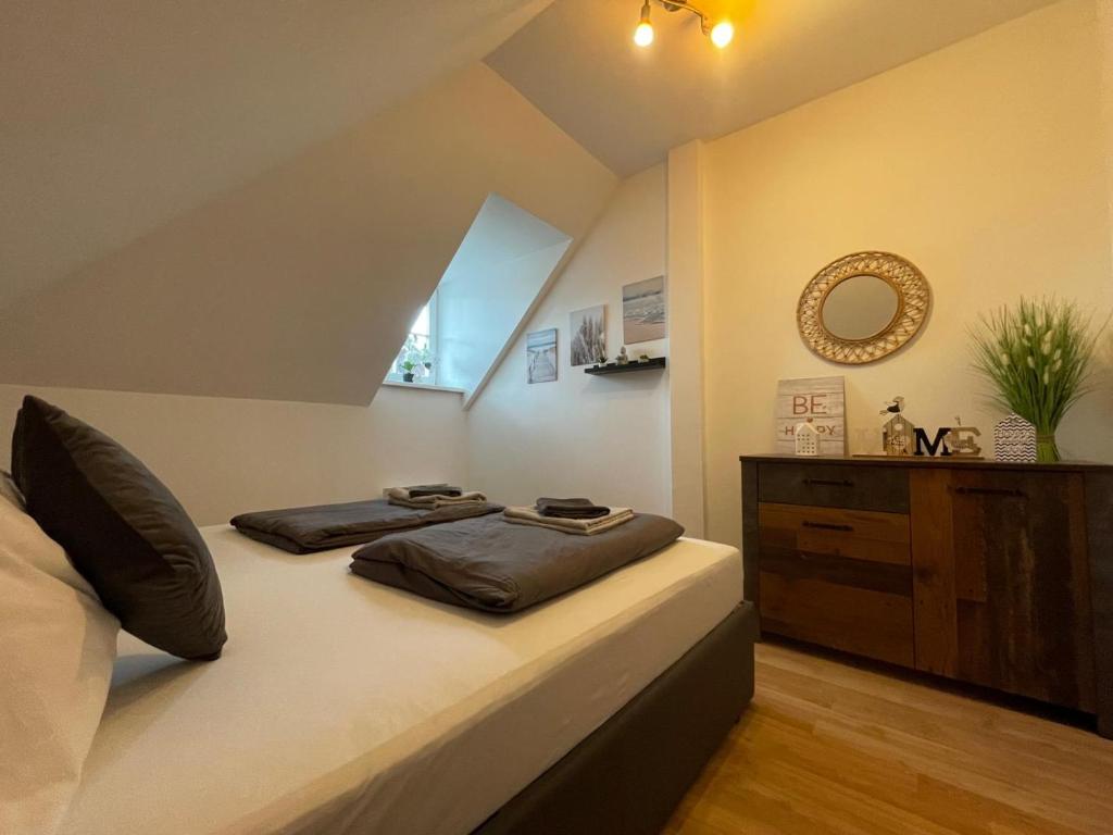 a bedroom with a bed and a mirror and a dresser at BullsLiving Seeapartment 5 in Velden am Wörthersee