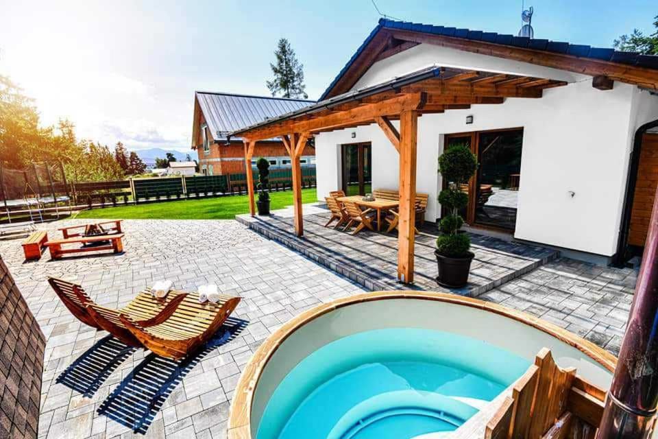a backyard with a swimming pool and a house at Wellness Villa Bobrik in Pribylina