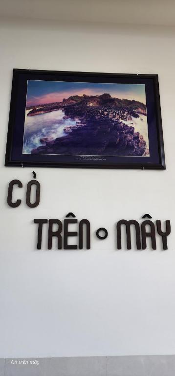 a tv on top of a white wall with a sign at Homestay Cỏ trên Mây in Liên Trì (4)