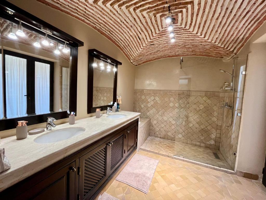 a large bathroom with a shower and a sink at Villa Sofia - Golf Amelkis Marrakech in Marrakesh