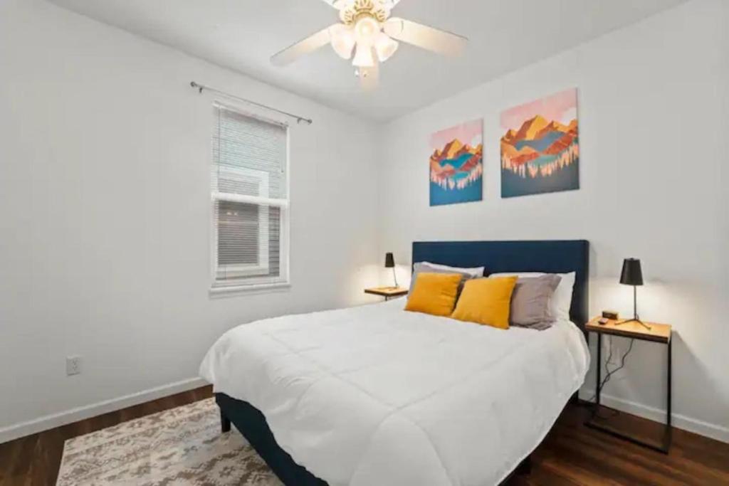 a white bedroom with a bed and a ceiling fan at Multiple homes side by side downtown in Indianapolis