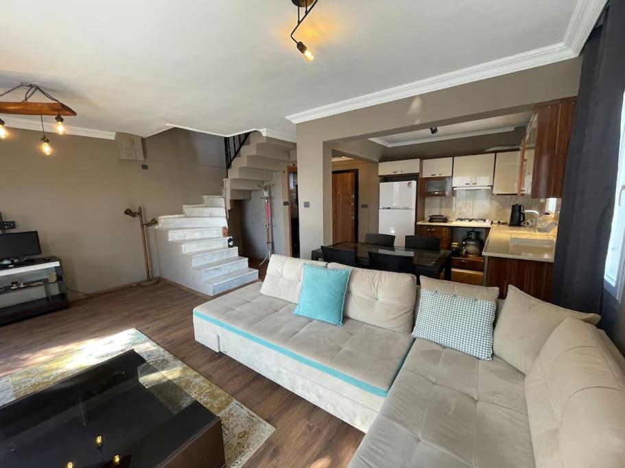 a living room with a white couch and a staircase at Merkezde denize 5 dakika villa in Kusadası