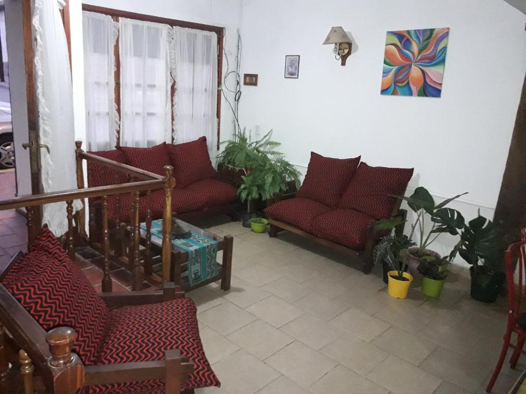 a living room with red couches and plants at La Posada del Rey in Mina Clavero