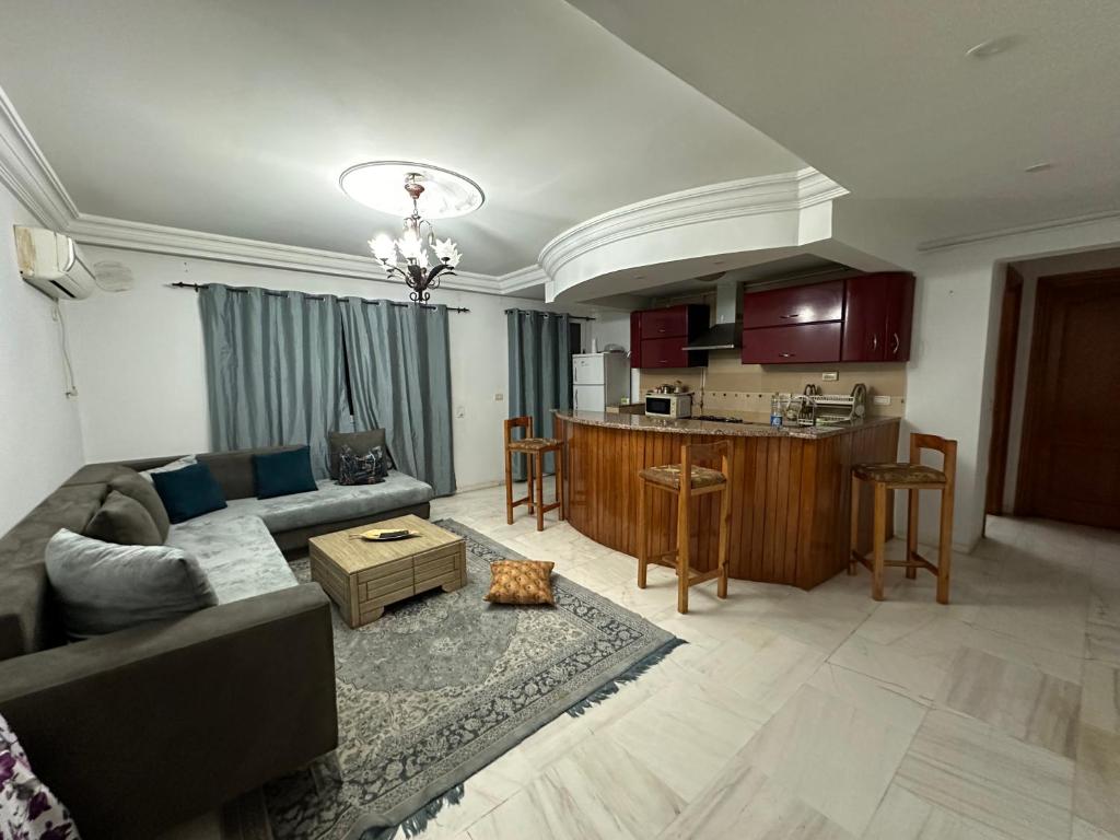 Il comprend un salon avec un canapé et une cuisine. dans l'établissement Coquette appart de plage, à Hammam Sousse