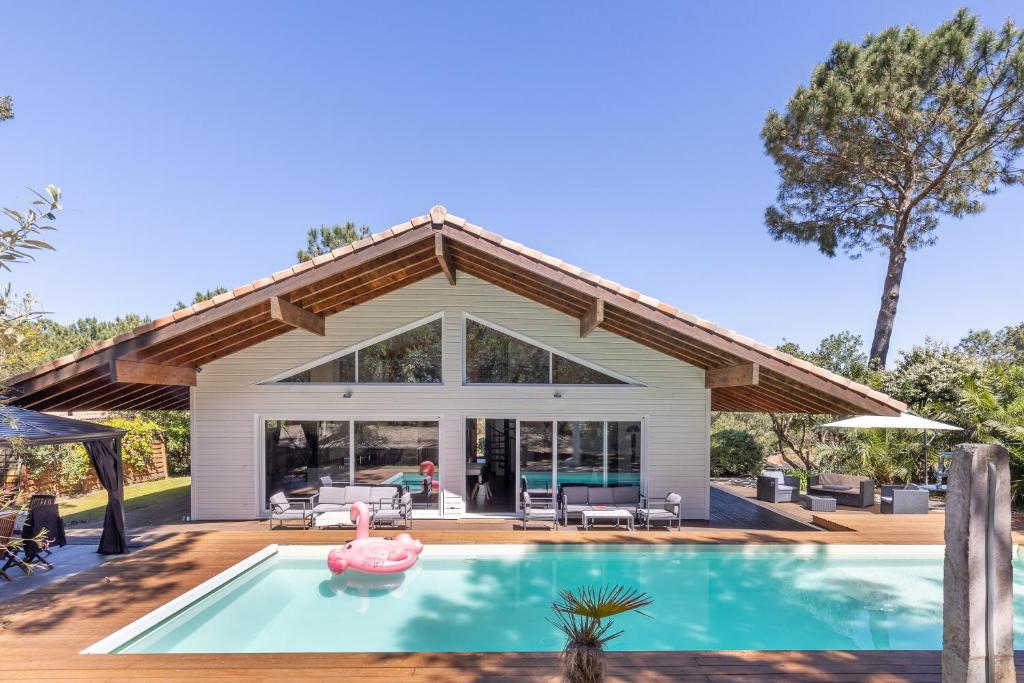 une piscine devant une maison dans l'établissement Villa Nature, piscine chauffée, à Moliets-et-Maa