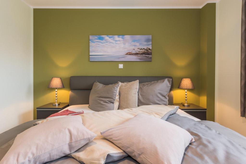 a bedroom with a large bed with two lamps at Birkenstraße 6 Haus II Whg2 in Zingst