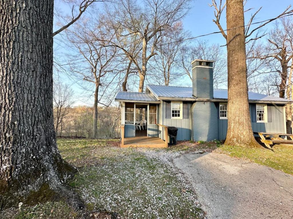 an old house with a porch and a tree at Cottage 6- Lees Ford Marina in Nancy