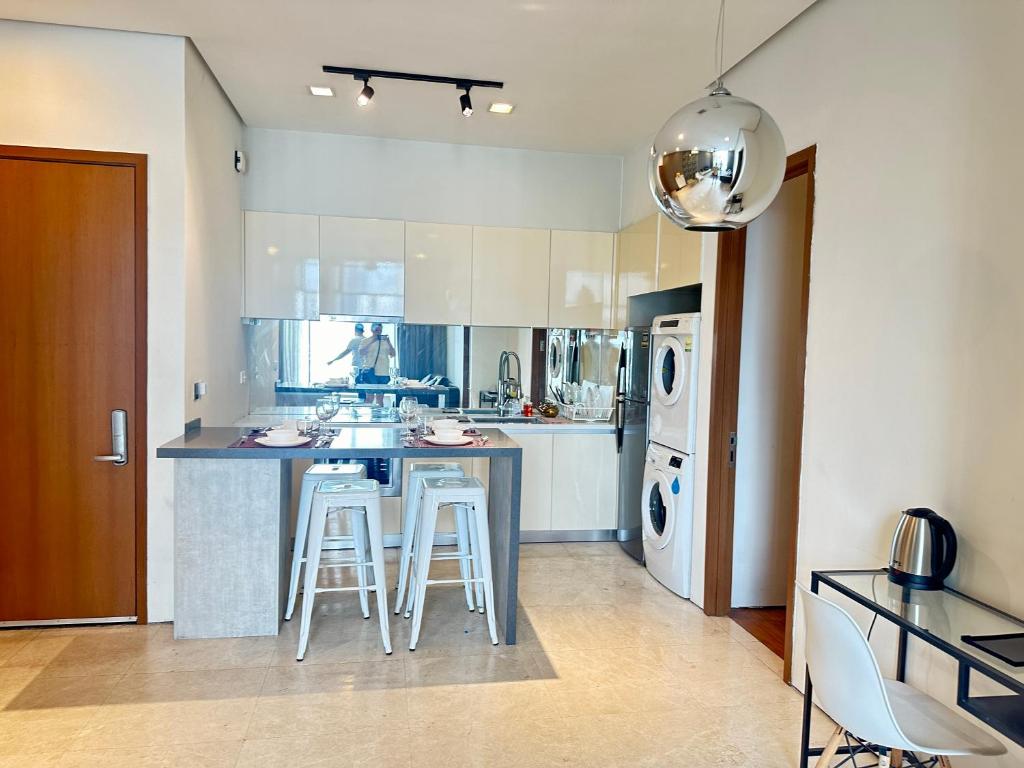 a kitchen with a counter and stools in it at 2bedroom soho suites klcc in Kuala Lumpur