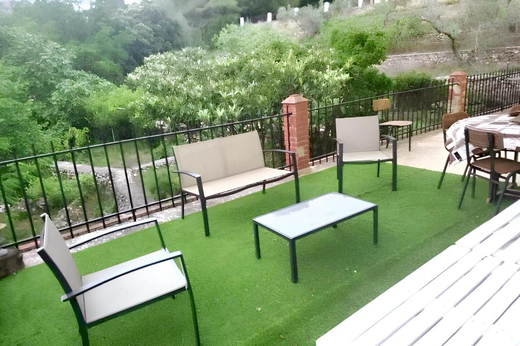 a group of chairs and tables on a balcony with green grass at 3 bedrooms house with enclosed garden at Simat de la Valldigna in Bárig