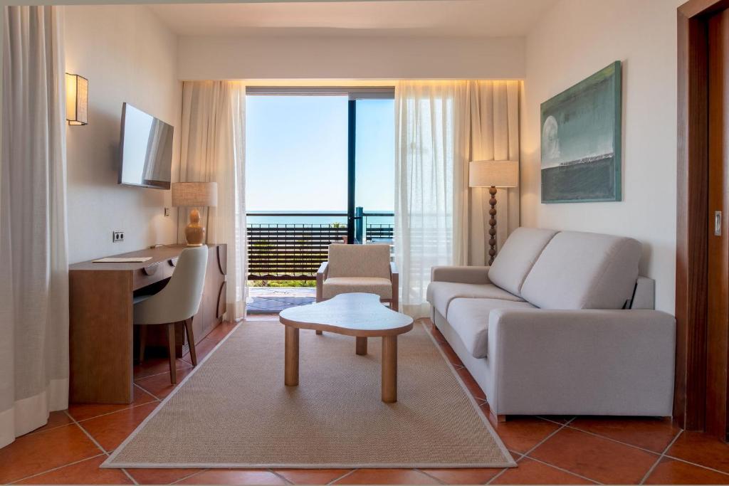 a living room with a couch and a table at Puerto Antilla Grand Hotel in Islantilla
