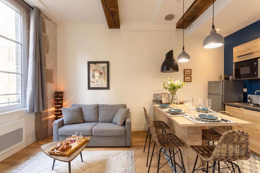 un salon avec un canapé et une table dans l'établissement Le Kodama - Appt en plein coeur de St Malo, à Saint-Malo