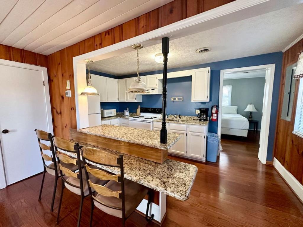 eine Küche mit blauen Wänden sowie einem Tisch und Stühlen in der Unterkunft Cottage 7 Lees Ford Marina in Nancy
