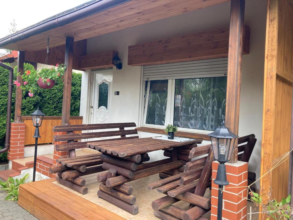 een houten terras met een houten tafel en banken bij domek letniskowy in Małe Swornigacie