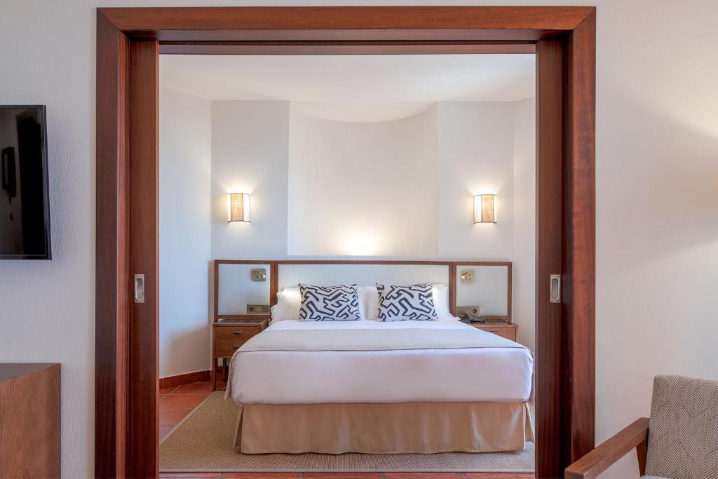 a bedroom with a bed and a large mirror at Puerto Antilla Grand Hotel in Islantilla
