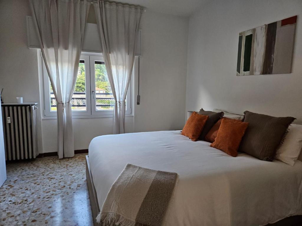 um quarto com uma grande cama branca e uma janela em La Mansarda em Como