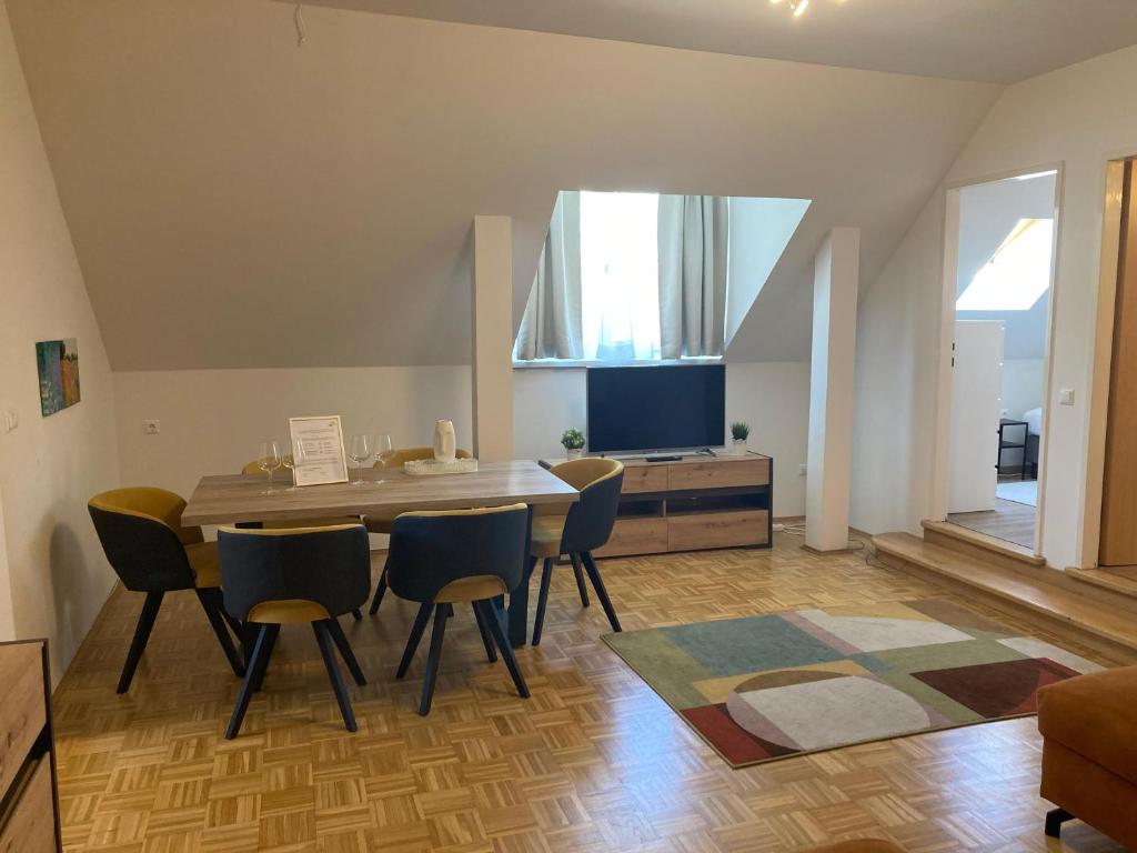 un salon avec une table et des chaises de salle à manger dans l'établissement BullsLiving Seeapartment 4 AM CORSO, à Velden am Wörther See