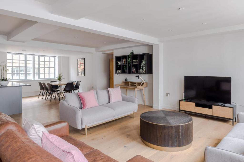 ein Wohnzimmer mit einem Sofa und einem Tisch in der Unterkunft Circus of Colour - Farringdon - by Frankie Says in London