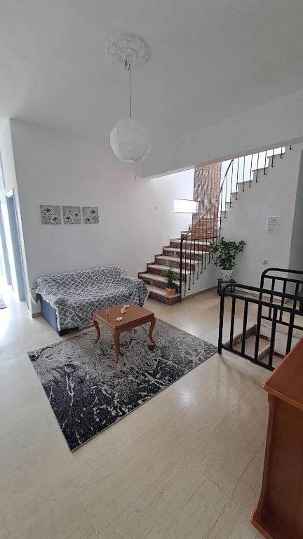 - un salon avec une table basse et un escalier dans l'établissement KONSTANTINA Rental Rooms, à Menídion