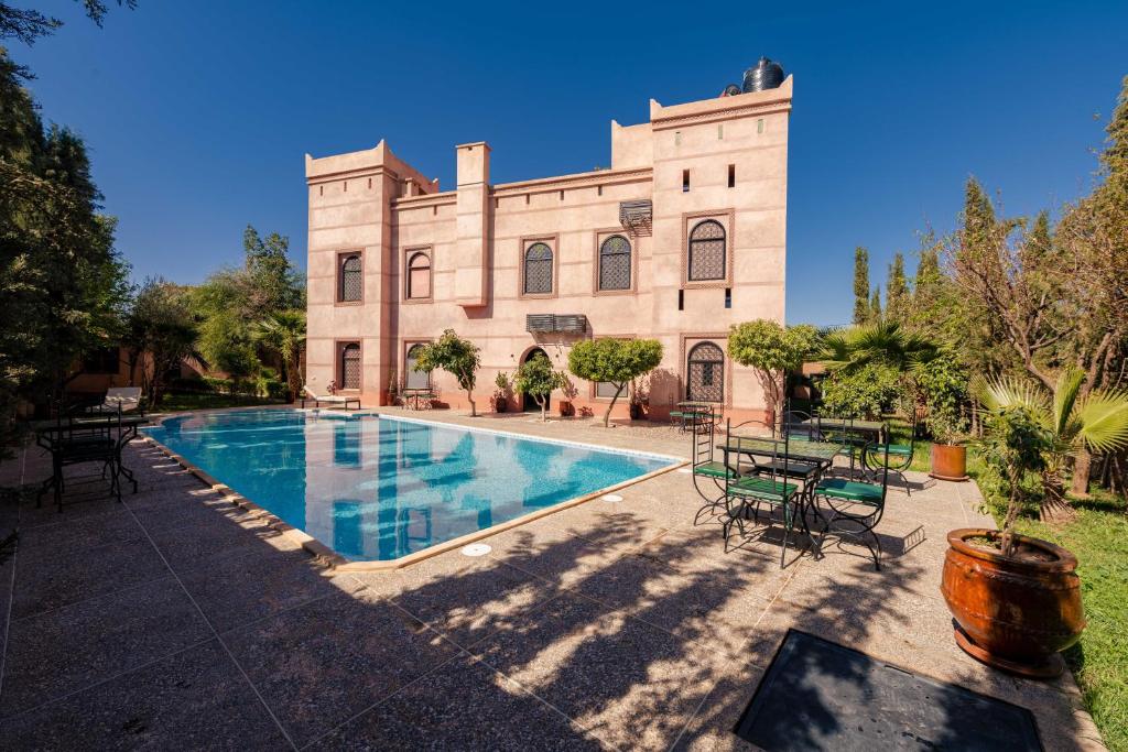 a large building with a swimming pool in front of it at Riad Zinaida in Aït Bou Zguia
