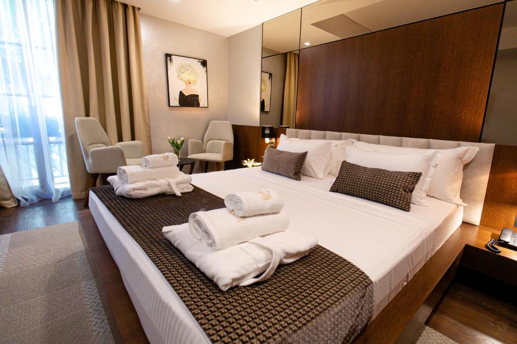um quarto de hotel com uma cama grande com toalhas em Hotel Sokrati em Tirana