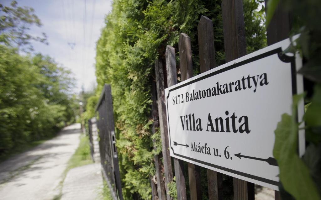 a sign on a fence next to a street at Villa Anita - 100 metrov od pláže Bercsényi in Balatonakarattya
