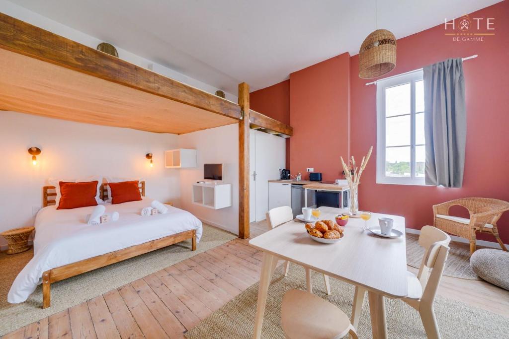een slaapkamer met een bed en een tafel in een kamer bij Appartement rénové, situation idéale à Libourne in Libourne