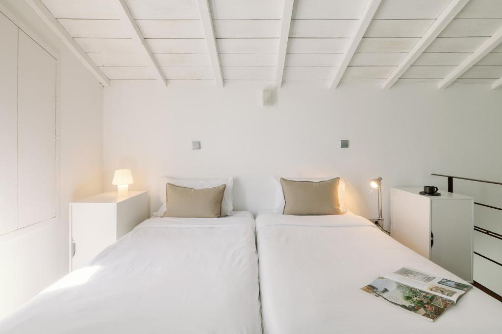 2 camas en una habitación con paredes blancas en Fine Arts Studios by Olala Homes, en Oporto