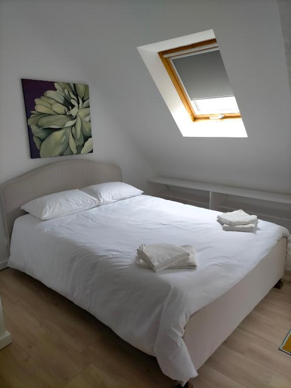 a white bed with two towels on top of it at Le 1 St Yves Studios in Tréguier