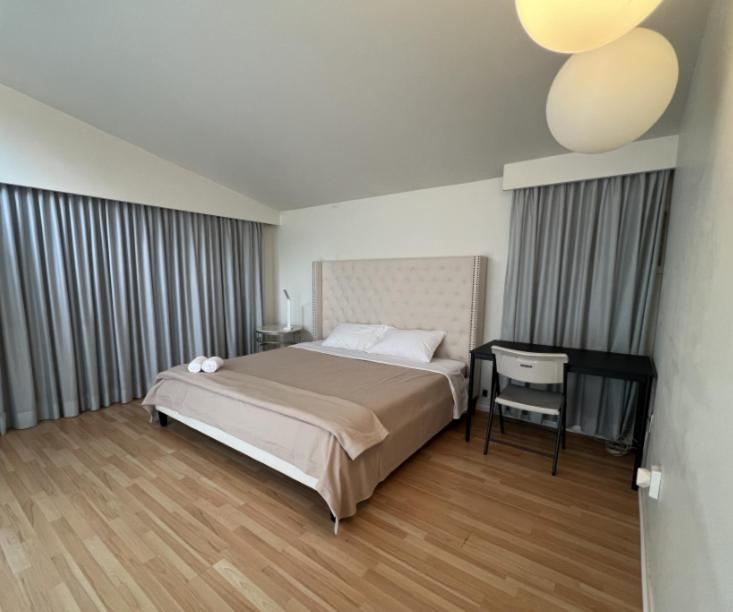 a bedroom with a bed and a table and a chair at vihome-one Queen bedroom near Bayview Village in Toronto
