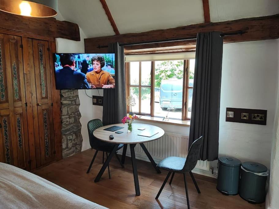 um quarto com uma mesa e uma televisão na parede em Catstone Lodge Studio 2 em Mullingar