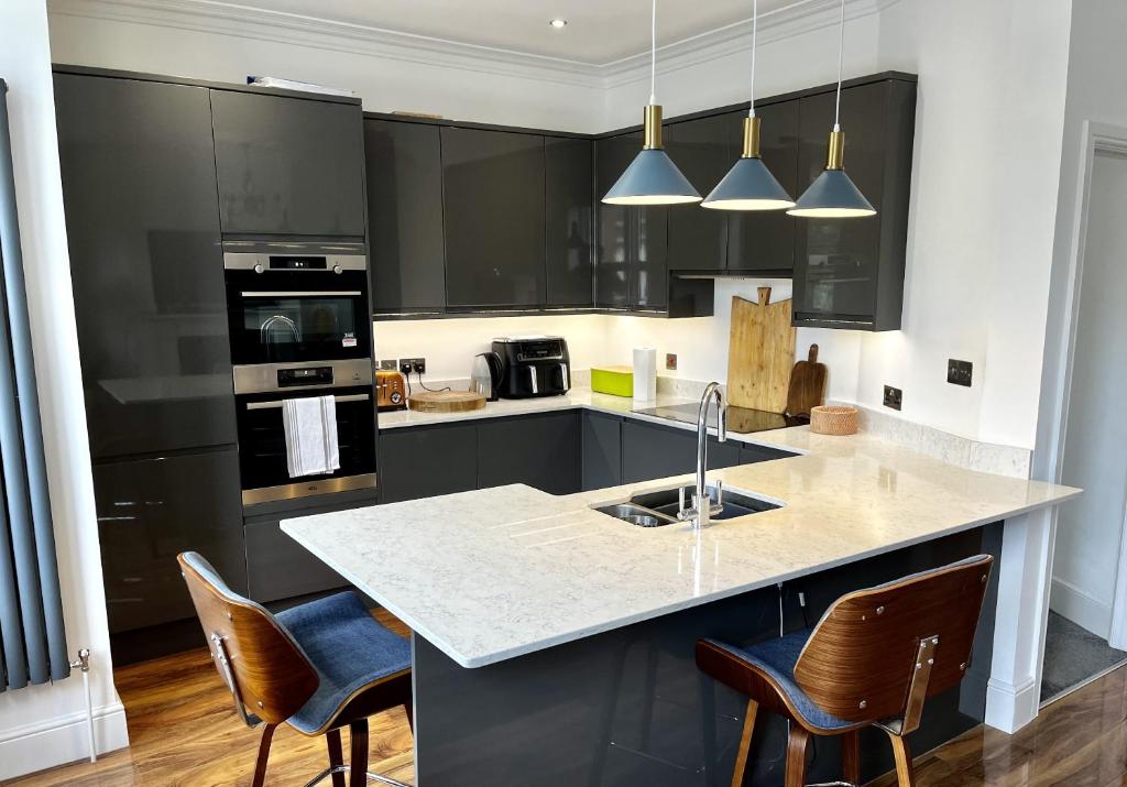 uma cozinha com armários pretos e um balcão branco em Luxury apartment with 2-Beds em Beckenham
