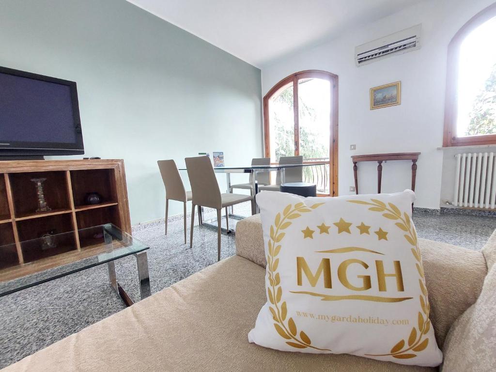 een woonkamer met een bank en een tv bij My Garda Holiday Home Peschiera 1 in Peschiera del Garda