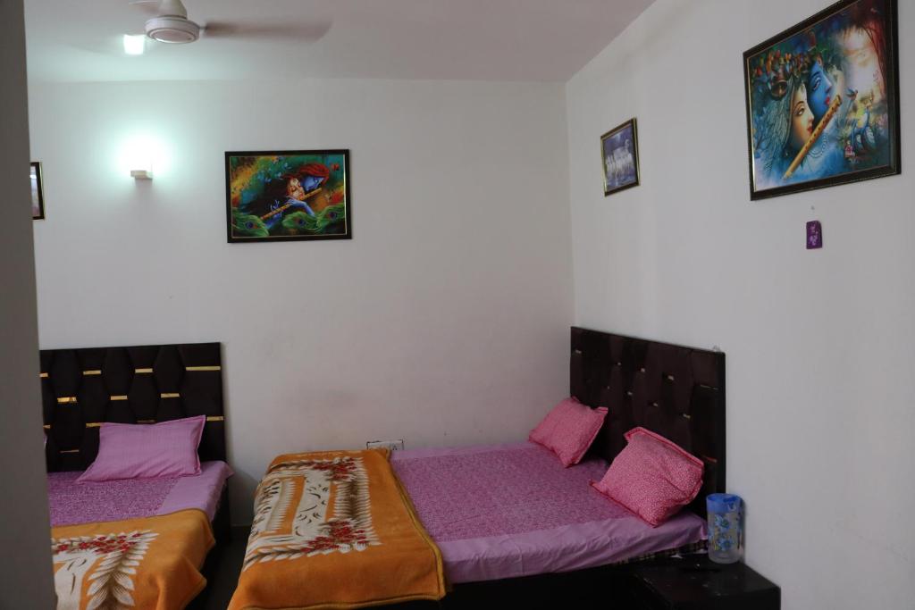 2 letti in una camera con lenzuola viola di Omaxe Eternity-Near Prem Mandir a Vrindāvan