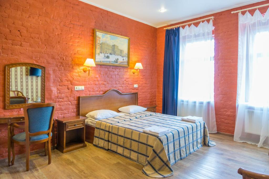 a bedroom with a bed and a brick wall at RA na Rybinskoy 7 in Saint Petersburg
