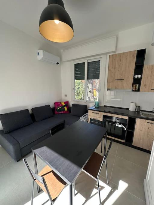 ein Wohnzimmer mit Tisch und Couch in der Unterkunft Appartamento a pochi passi dal mare in Bellaria-Igea Marina