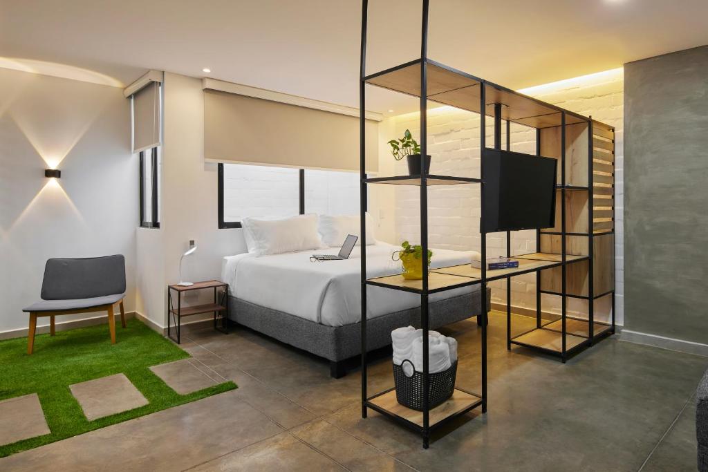 een hotelkamer met een bed en een televisie bij Altio Hotel in Cali