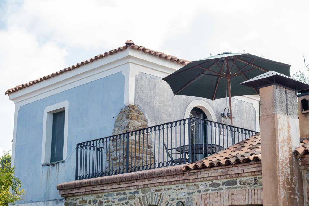 a balcony with an umbrella on top of a house at Sparviero - ACrapa Mangia in Santa Maria di Castellabate