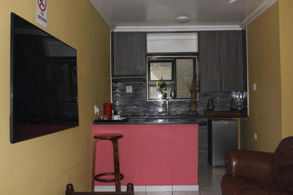 una cocina con una isla roja en una habitación en DreamWest Living The Guesthouse, en Krugersdorp