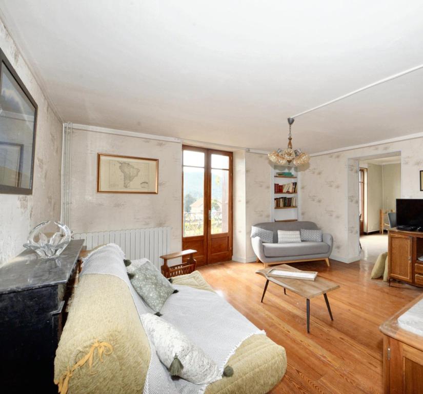 ein Wohnzimmer mit einem Sofa und einem Tisch in der Unterkunft Maison de 3 chambres avec balcon et wifi a Aspres sur Buech in Aspres-sur-Buëch