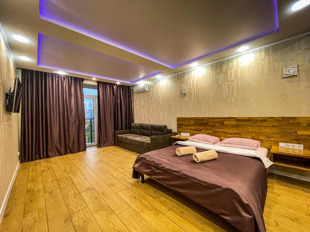 um quarto com uma cama grande e um sofá em Новобудова в Центрі біля набережної em Kremenchuk