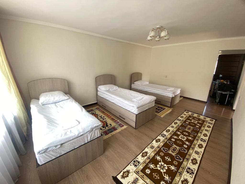 um quarto com duas camas e um tapete em 31 em Naryn