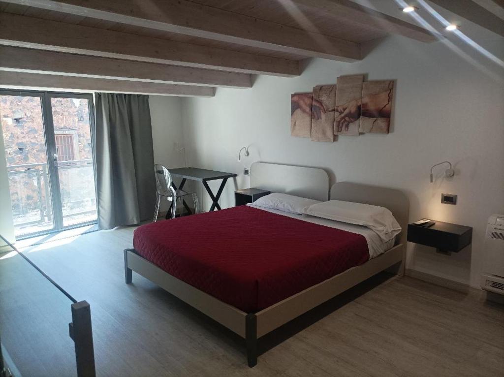 um quarto com uma cama grande e um cobertor vermelho em CARLO'S Home em Catânia