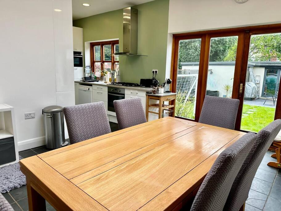 cocina con mesa de madera y sillas en 4 bed family home + Garden Twickenham., en Twickenham