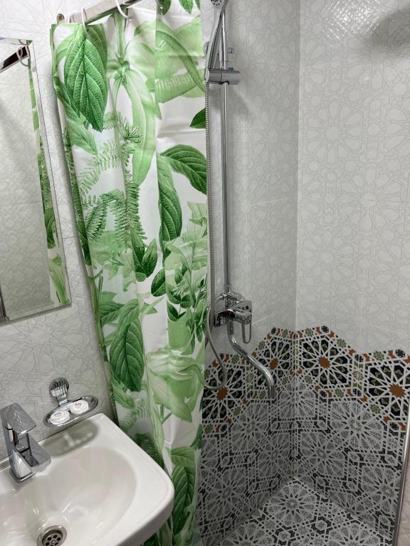 a bathroom with a shower with a sink and a toilet at Old Palace Hotel in Samarkand