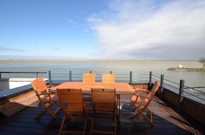 a table and chairs on a deck with a view of the water at 25 Quai Blavet in Saint-Valéry-sur-Somme
