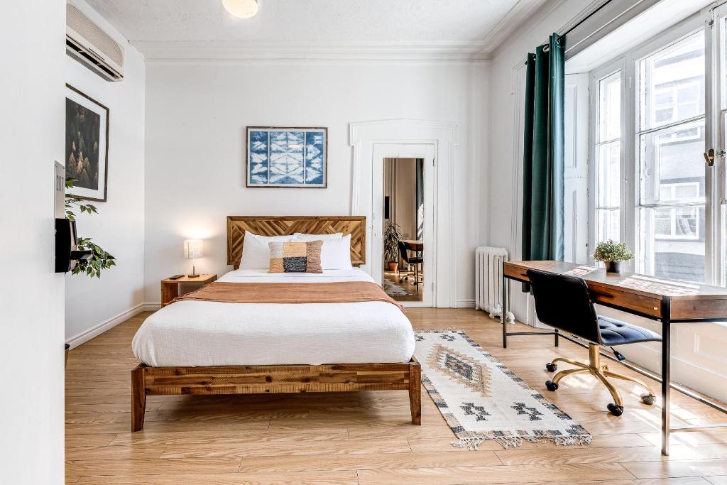 1 dormitorio con cama y escritorio en Hôtel Automatisé Manoir des Remparts, en Quebec