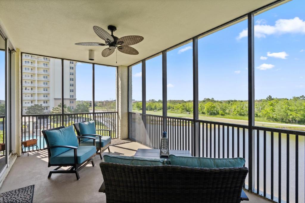 a screened in porch with chairs and a ceiling fan at Santo Amaro Unit 301B at Lost Key Golf & Beach Club in Pensacola