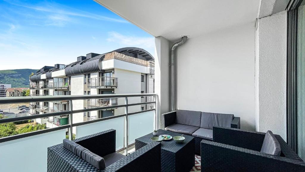 un balcon avec deux chaises et une table sur un immeuble dans l'établissement HOMEY CHLOE - New - Parking gratuit - Balcon privé - Proche Genève, à Annemasse