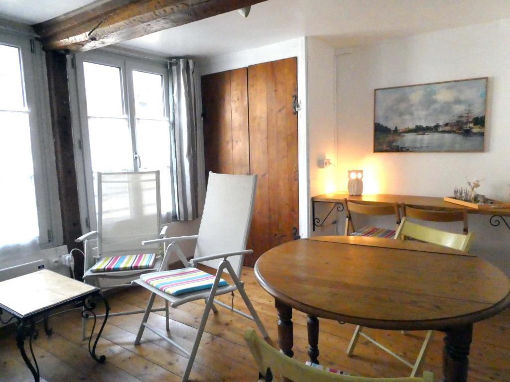 - un salon avec une table et des chaises en bois dans l'établissement L'avocette élégante, à Saint-Valery-sur-Somme