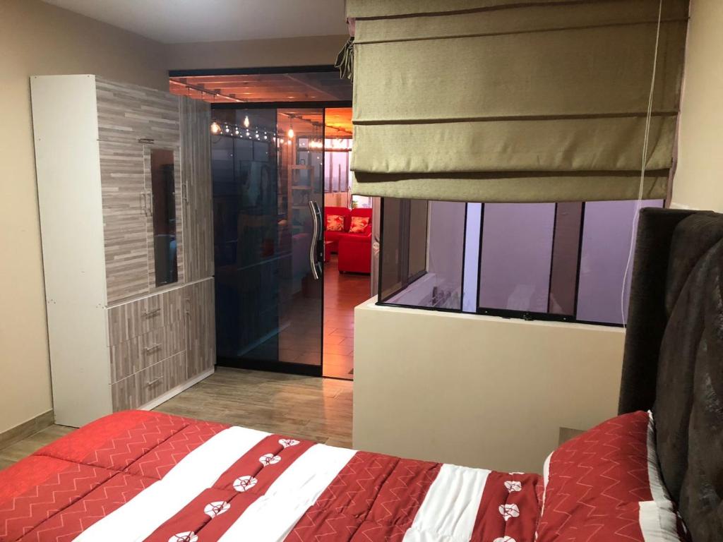 Un dormitorio con una cama y una ventana con un ciego en The Big blue house en Chimbote